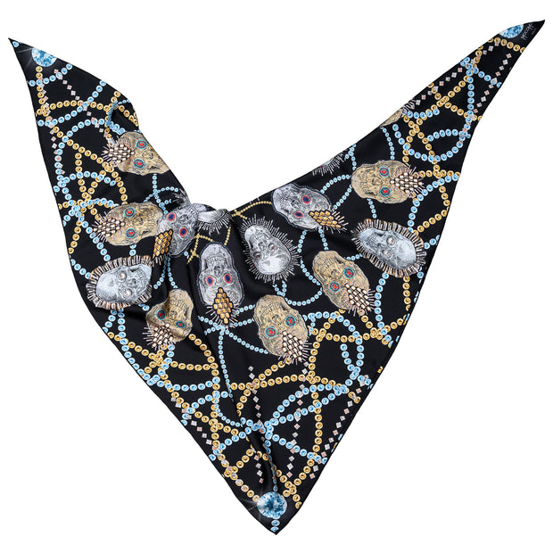 street-art-silk-scarf-by mocomoco-berlin-motif-london-artist-uberfubs-motif-sculls-and-jewellery-black-gold-silver-140x140cm-lying-folded-in-bird-wing-shape
